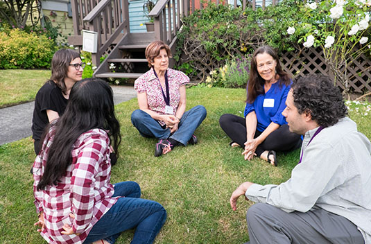 Madeline Hartman sitting on grass with Psychic Tools students
